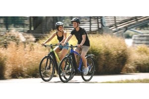Cycling couple riding through cycle path in the city