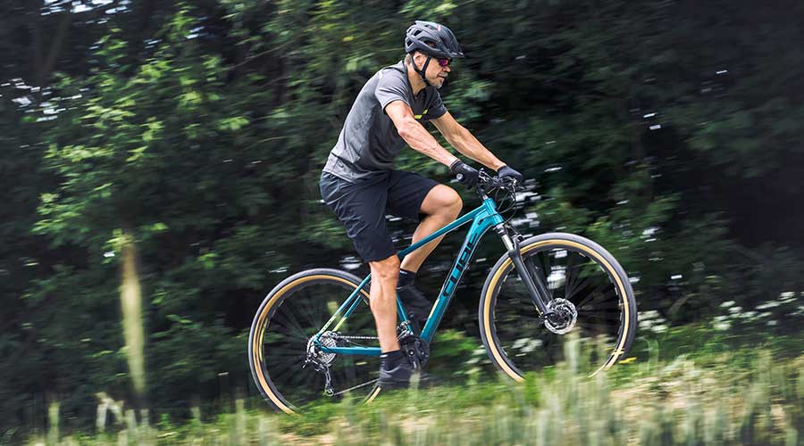 Cyclist riding uphill on Cube Aim SL Hardtail Mountain Bike