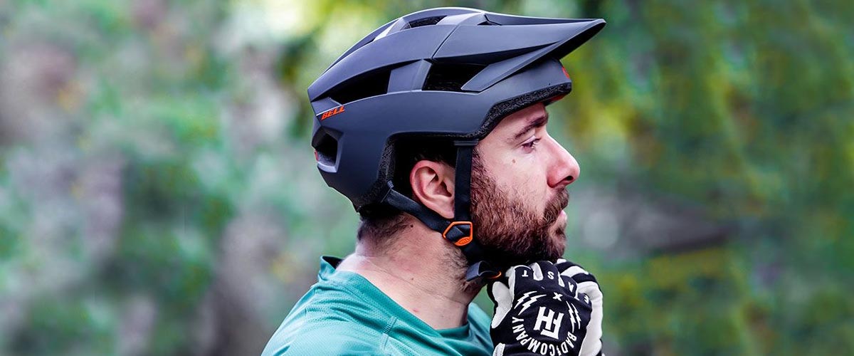 Cyclist securing mountain bike helmet on