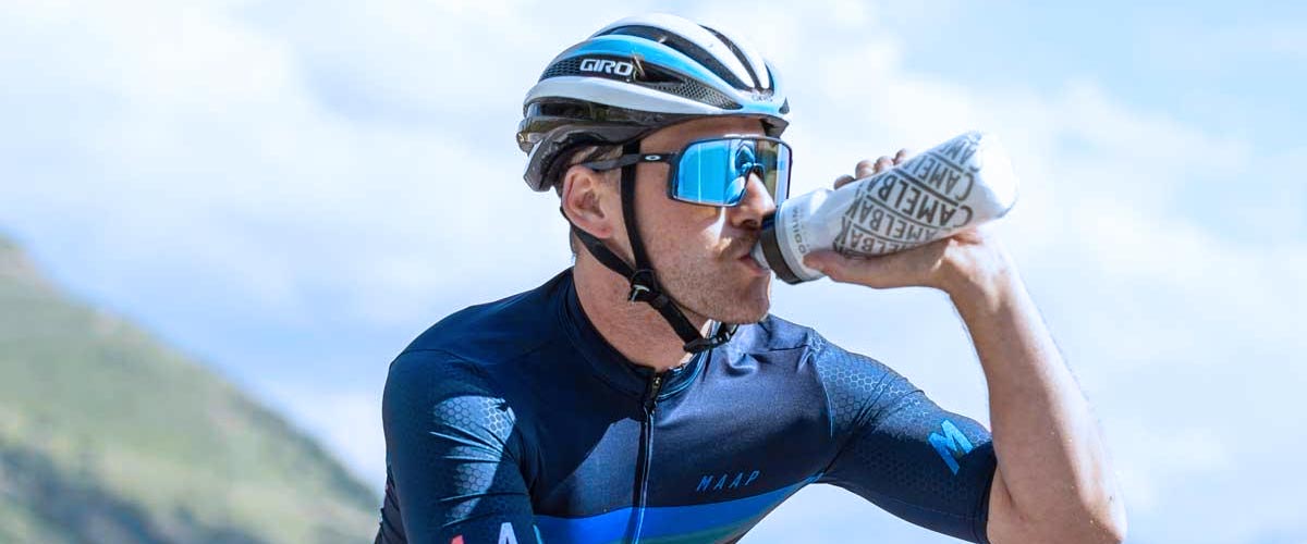 Cyclist riding bike and drinking from water bottle