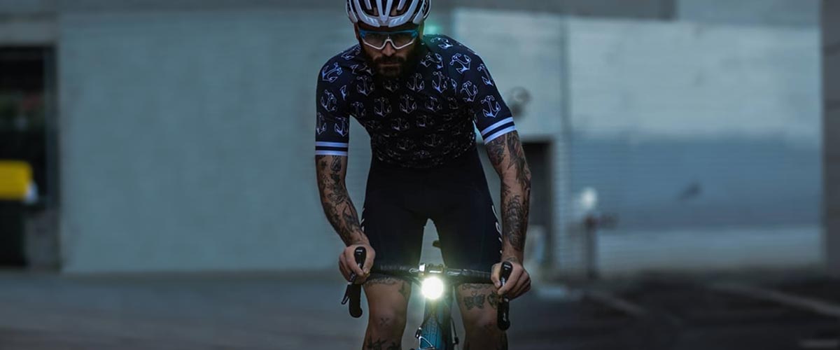 Cyclist riding bike in dark street, with bike light