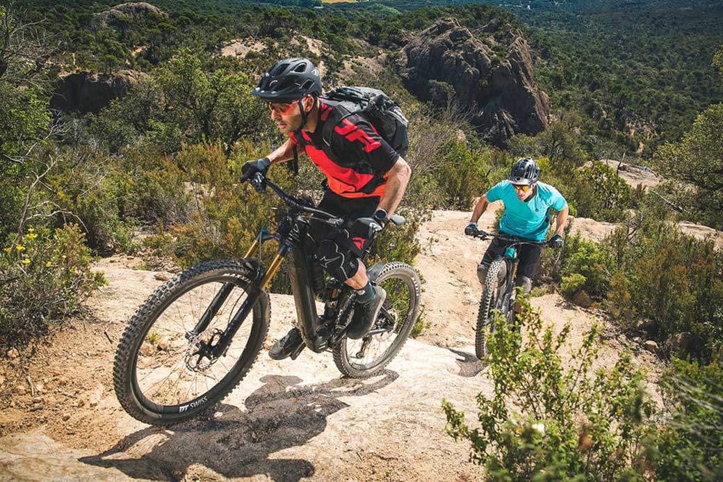 two cyclist riding up-hill in country area