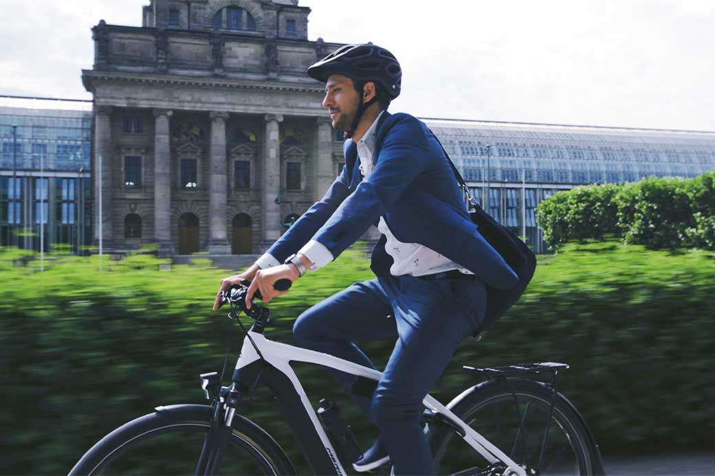 cyclisting speeding past city building on the way to work