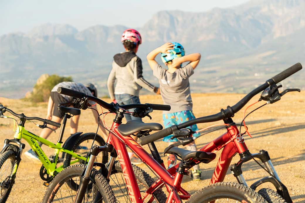 Kids at top of mountain bike trail with 3 Silverback kids bikes behind them