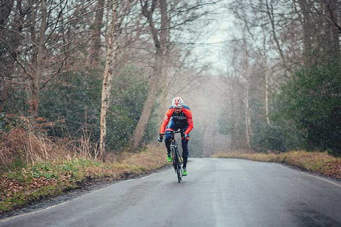 Silveback rider cycling in misty winter day on an empty road